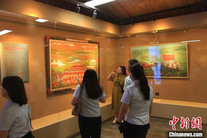 图为游客驻足蒙古族皮艺传习基地欣赏皮雕画。　莫尼山非遗小镇供图